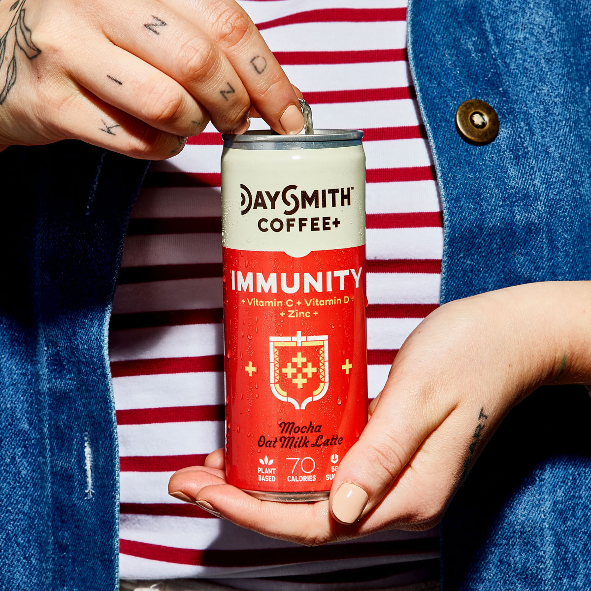 Woman holding a can of Daysmith+ Coffee.